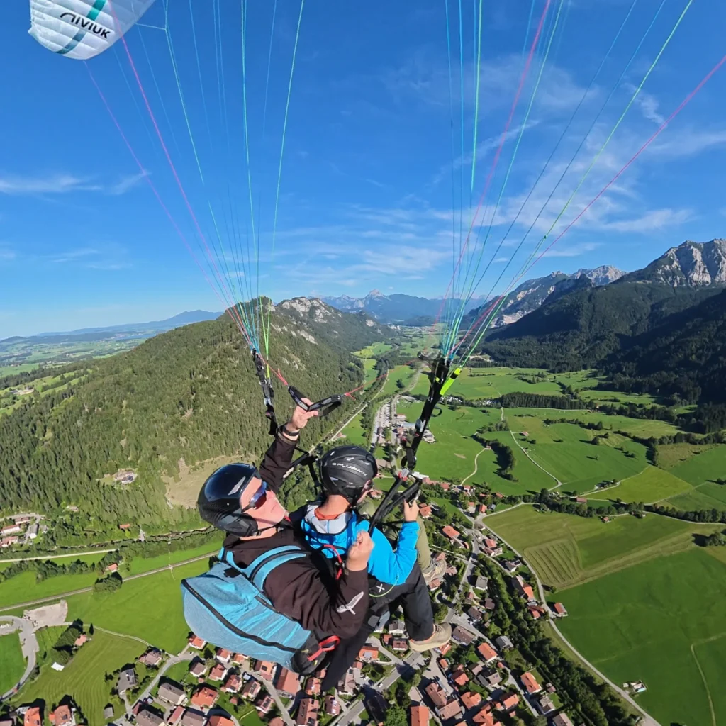 Tandemflug mit dem Gleitschirm über der Allgäuer Berglandschaft bei Pfronten